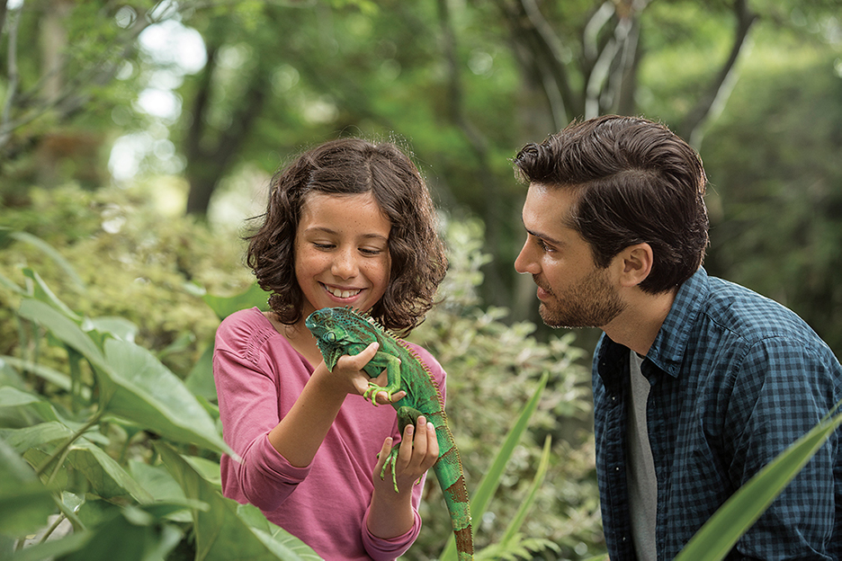 Man and child holding a lizard